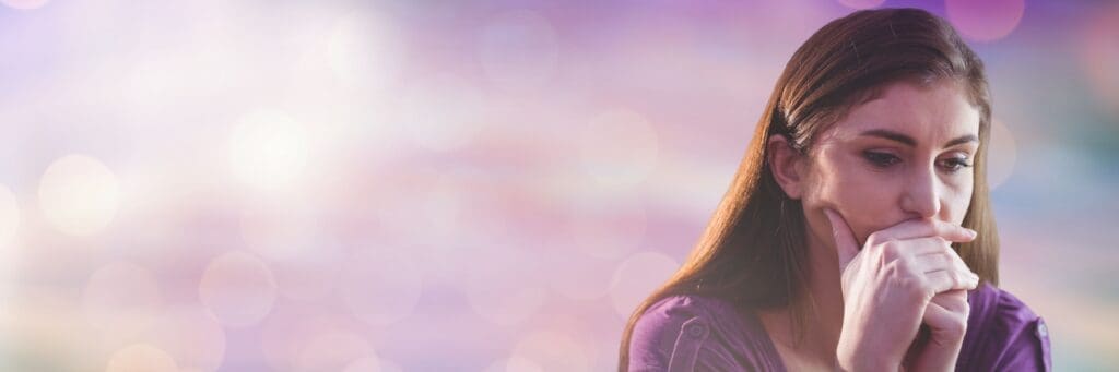 Worried woman sitting thoughtfully with her hands near her face, representing emotional distress and signs that counseling may help.